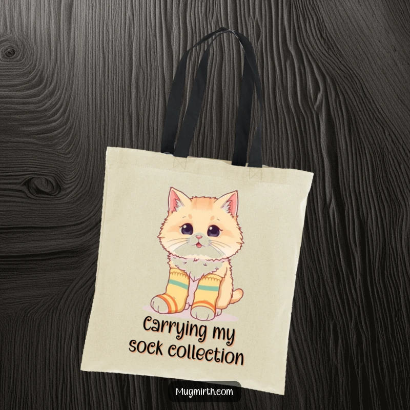 Funny tote bag with a fluffy cat hilariously attempting to wear oversized, mismatched socks, ideal for carrying quirky essentials.
